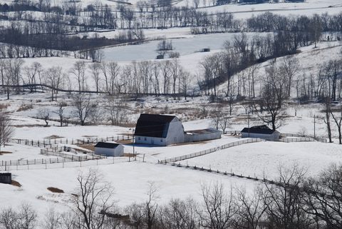 Snow-covered farm fields, fence lines and outbuildings at Sky Meadows State Park, Virginia