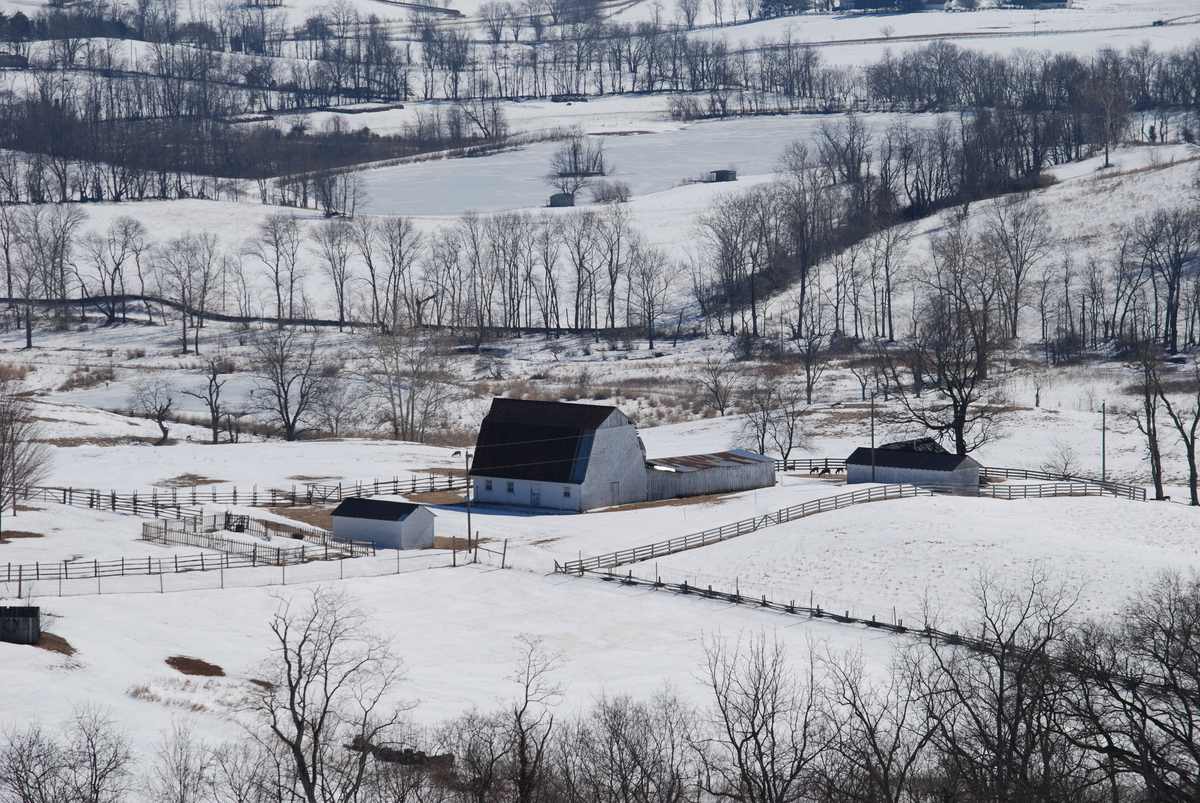 Snow-covered farm fields, fence lines and outbuildings at Sky Meadows State Park, Virginia