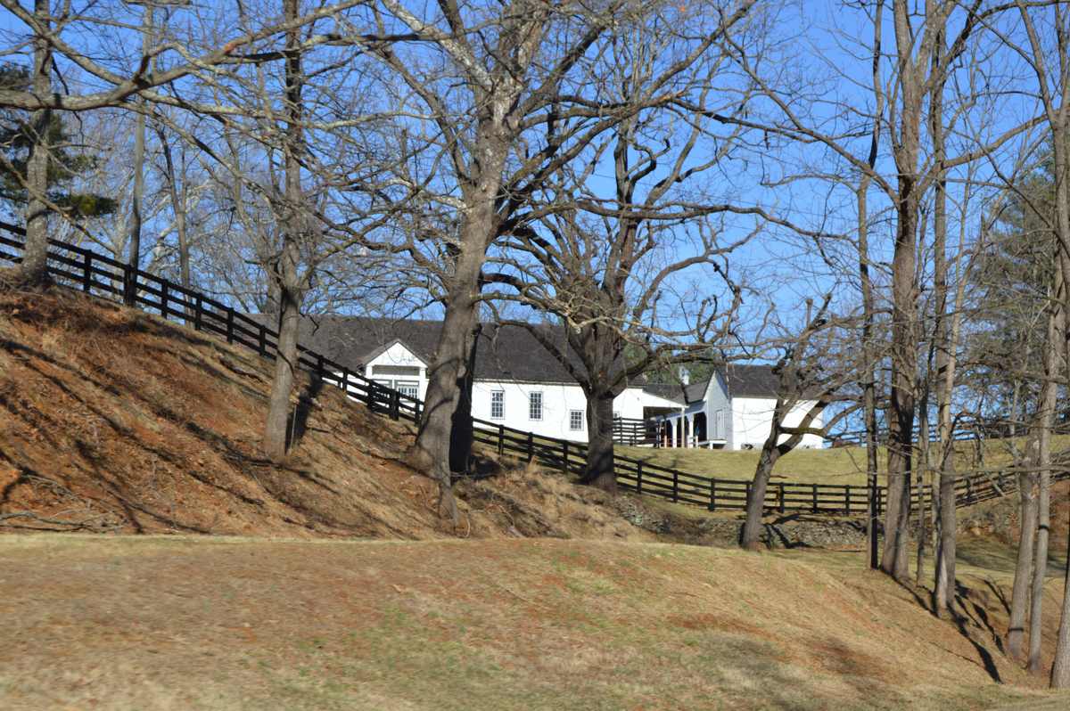 Farm buildings and board fencing on the hillside at Seven Oaks Farm, Albemarle County, Virginia