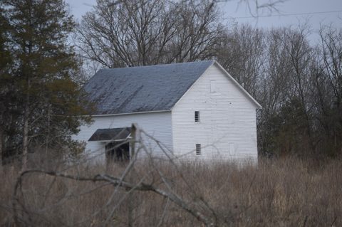 Wooden farm outbuilding in a grass field at Rivanna Farm in Fluvanna County, Virginia